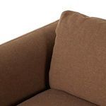 Corner of back cushion meeting armrest, showcasing fabric weave and plush filling
