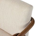 Close-up of curved oak backrest frame and beige fabric upholstery on Rosie chair