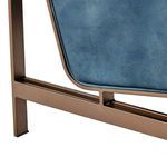 Detailed focus on bronze metal frame corner beneath navy leather upholstery