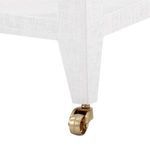Close-up of brass caster wheel detail on white textured Isadora Tea Table leg