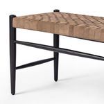 Close-up on the intersection of the bench's leather weave and rounded black oak leg tips