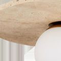 Close-up of textured beige travertine disc surface showing natural stone details