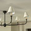 Side view of chandelier showing two shades with visible candle-like light sockets under linen shades