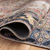 Rolled section of the rug on wooden floor highlighting the woven edge and backing texture