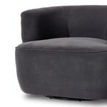 Partial side view focusing on swivel base and fabric upholstery