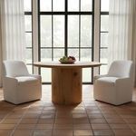 Two Maisie rolling dining chairs arranged around round wooden table in bright dining room