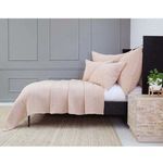 Side angle of the Vancouver Coverlet on bed showing drape and matching pillows against gray wall