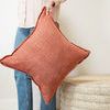 Hand holding pillow by corner showcasing its square shape and visible flange