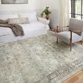 Living room setting with Rosette rug under light gray armchair and white couch