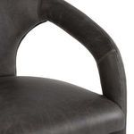 Close-up of smooth distressed leather texture on seat and armrest showing fine stitching