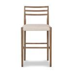 Front view showing the squared seat cushion framed by smoked oak legs and footrest bars