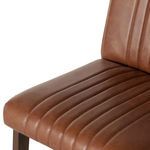 Close-up of chestnut leather seat with vertical channel tufting and side wood frame