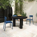 Side view of Kent chairs and black round table in outdoor patio setting with greenery