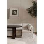 Partially styled dining banquette corner with dark wooden oval table and wall art in room context