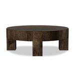 Round coffee table viewed at an alternative side angle emphasizing chunky legs and uniform finish
