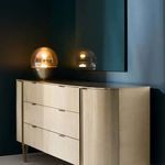 Love At First Sight dresser in room setting with dark wall, illuminated decorative orb on top, and mirror reflection