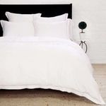 Sheena Bamboo Sateen Euro Sham styled on bed with matching pillows and black headboard in bright room