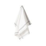 Soft white cotton kitchen towel with black embroidered border lines and fringed edges, hanging loosely