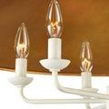 Close-up showing lit bulbs and curved white arms beneath snow white shade with gold interior