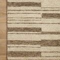 Close-up of rug corner on wood floor with clear wool and jute pile texture.