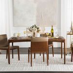 Rug as base under dining table with wood chairs and holiday decor in bright dining room
