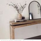 Close-up side angle highlighting wood grain with books and decorative vase