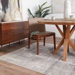 Side angle of Lavato Abstract rug in dining room emphasizing rug’s color blending with wooden floor and furniture