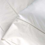 Close-up of ladder stitch detail on smooth cotton sateen fabric in crisp white pillowcase