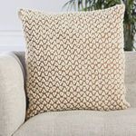 Pillow styled on beige textured sofa with indoor greenery background