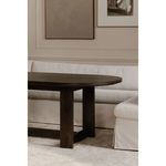 Close-up of dark wood dining table leg paired with slipped dining banquette in ambient dining room