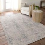 Rug placed in bright room with wood floor, styled with armchair and small table with decor