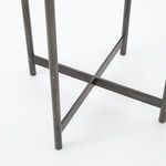 Bottom close-up on metal frame crossing and rounded leg ends with subtle shadow on white background