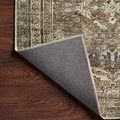 Back side of rug corner flipped over revealing dark backing fabric on wood floor