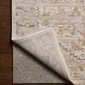 Corner of the rug flipped over to display the durable underside and a glimpse of a gray rug pad beneath