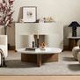 Living room setup with Nador grey rug anchoring modern furniture of cream sofa, round wood table, and curved chairs