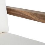 Close-up of teak wood armrest and white cushion edge showing grain detail and fabric texture