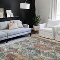 Skye Apricot / Mist Rug styled in modern living room with gray sofa, white armchair, floor lamp, and plant