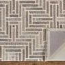 Back side of rug partially folded revealing gray and non-slip backing details