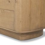 Close-up detail of rounded pedestal base and matching oak finish