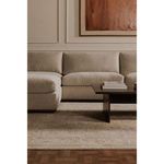 Close-up living room view featuring Rue Ottoman as sectional chaise with beige rug and abstract art