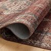 Close-up of Anniston Spice Multi rug edge partially rolled to reveal woven polyester backing texture