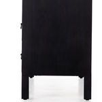 Close side view of raised square wood leg and black side panel surface