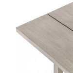 Angle detail showing beveled edge of tabletop and subtle weathered finish on teak wood