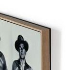 Close-up focusing on Ronald Reagan's face in the black and white cowboy photo with slight blur