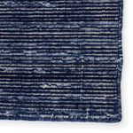 Close-up of rug surface texture highlighting navy and cream patterned fibers