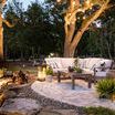 Evening view of outdoor seating area illuminated by string lights and lanterns with chair included
