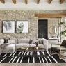 Wide shot of living room interior featuring two botanical paintings above gray sofa with timber ceiling beams