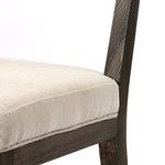 Close-up focusing on junction of wooden frame legs with seat cushion underside