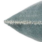 Close-up of pillow corner showcasing detailed hand-stitched white embroidery along the seam