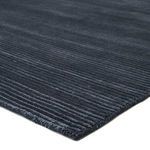 close-up of dark blue rug corner showing ribbed texture and thick wool-blend fibers
